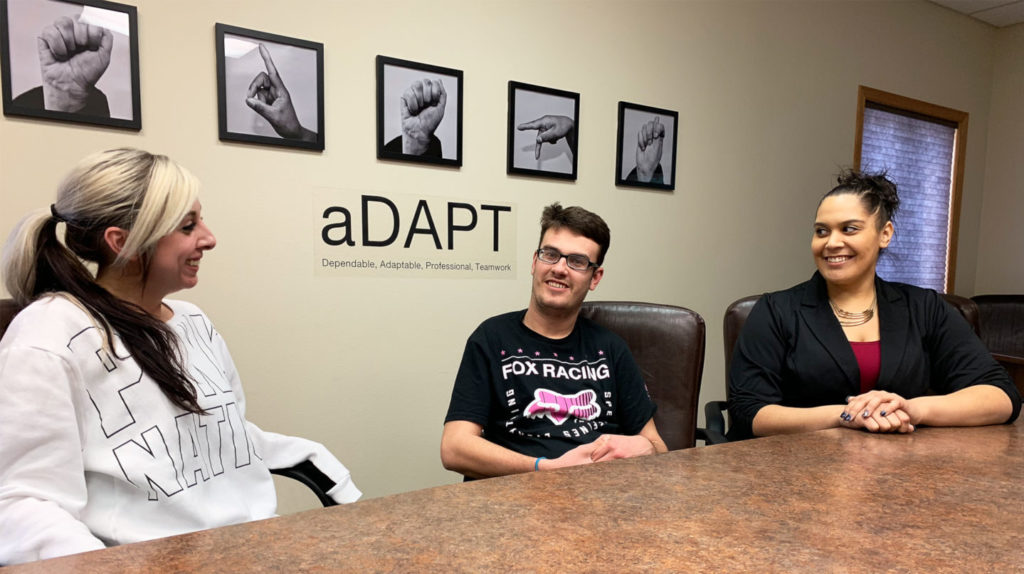 Three people sitting around a table.